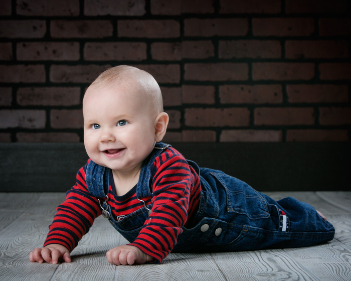 Five month old baby boy in bib overalls.