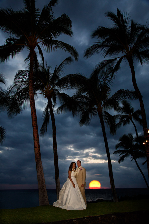 Hawaiian destination wedding. Bride and groom at sunset on the Pacific Ocean at Hilton Waikoloa Village. After enhancement.