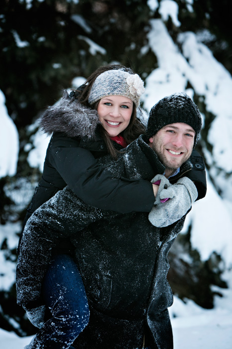 Winter engagement portrait of Grant and Christine playing in the snow at our Portrait Park.