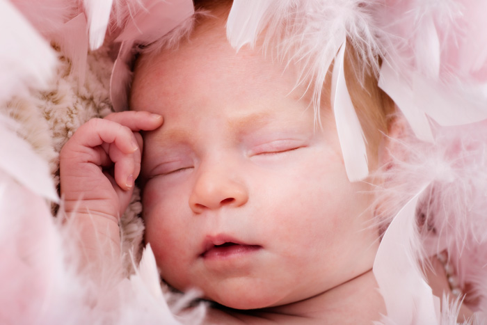 newborn-baby-girl-close-up-pink-feathers