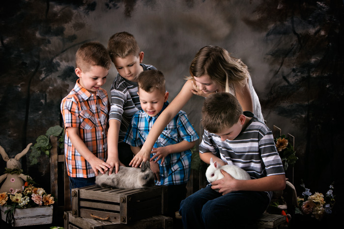 Five siblings get their Easter portraits taken with live bunnies.