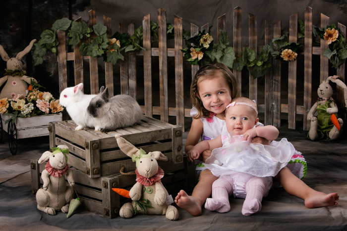 Two sisters with live bunnies for their Easter portraits in 2014.