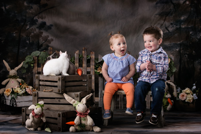 Two cousins have their Easter portraits taken with live bunnies.