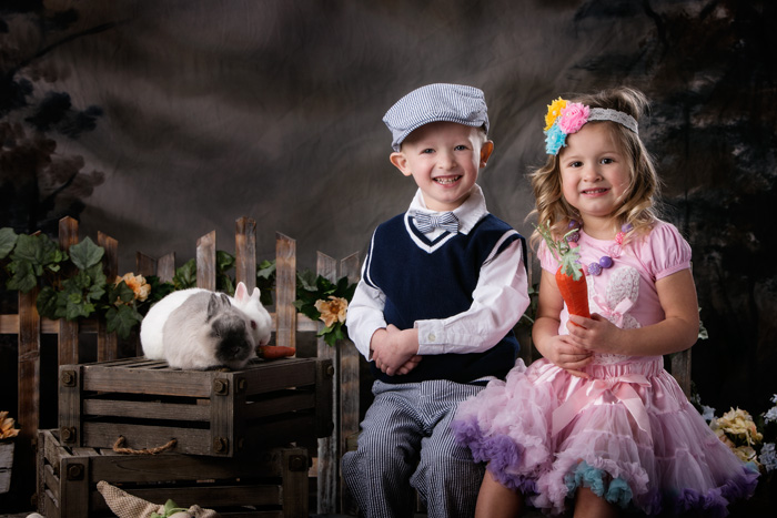 Brother and sister and their portraits with live bunnies.