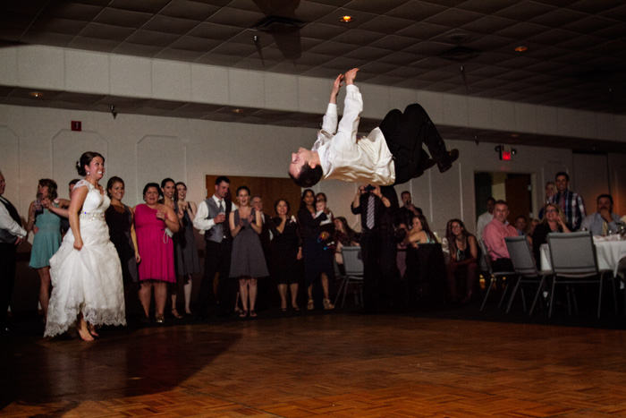 Groom does a flip during the bride and grooms first dance at their Royal Cliff wedding reception in Eagan, MN.