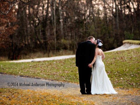 Bunker Hills Event Center wedding photograph of bride and groom kissing on the pathway.