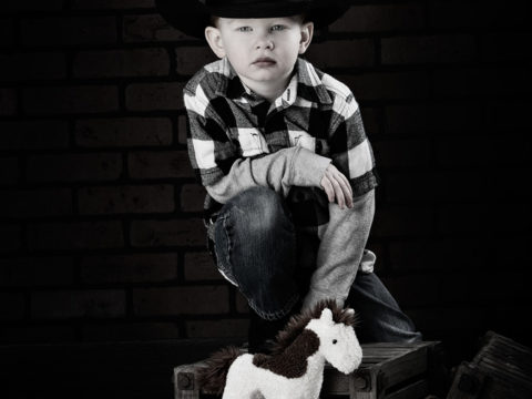 Three year old portraits of Isaiah in his cowboy hat.