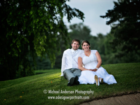 Bride and groom sitting in the grass at Southview Country Club.