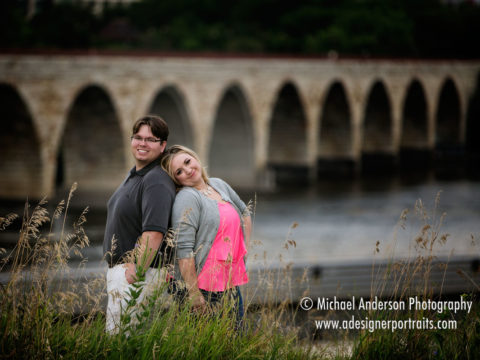 Engagement photography in Minneapolis of a cute couple with the Mississippi River & Stone Arch Bridge in the background.