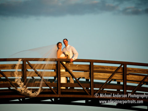 Pretty wedding photo of a bride & groom standing on a bridge just before sunset at The Links at Northfork wedding reception.