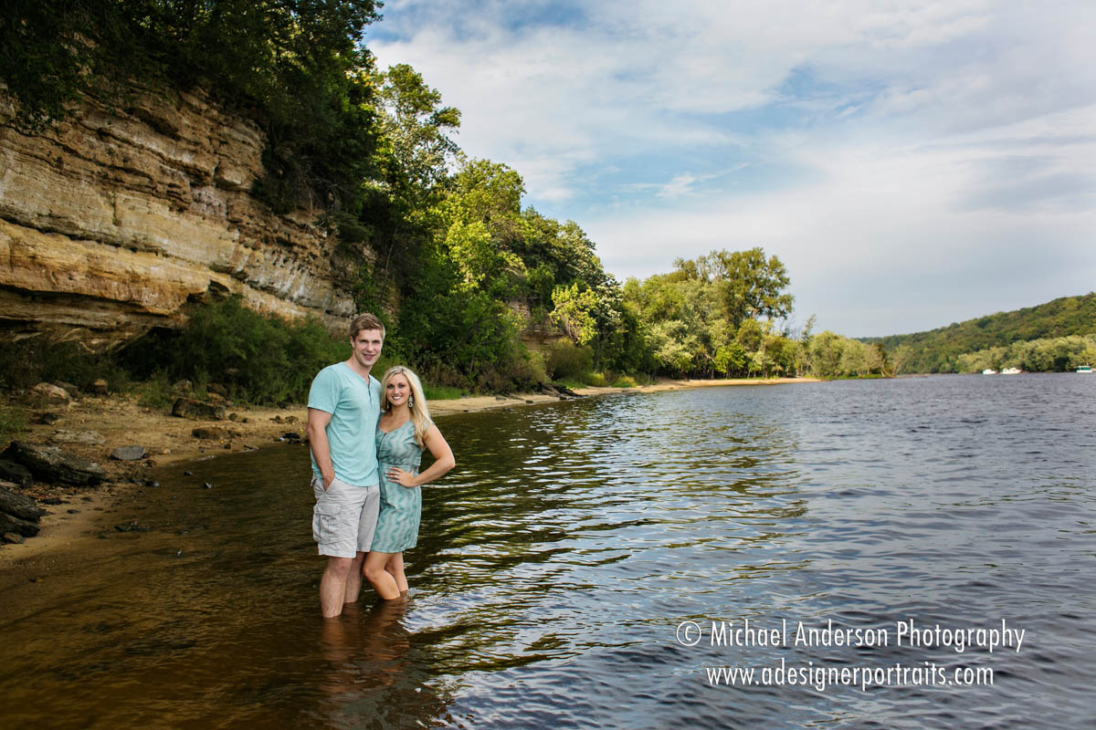 A cute couple standing in the St. Croix River during one of their engagement portraits in Stillwater, MN.
