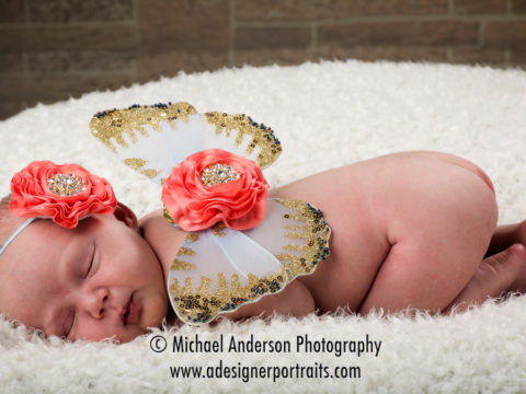 Baby girl newborn photos of a cute sleeping baby wearing fairy wings.