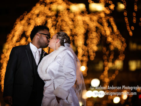Beautiful nighttime wedding photo of a bride & groom kissing under the pretty holiday lights at Rice Park in downtown Saint Paul, MN.