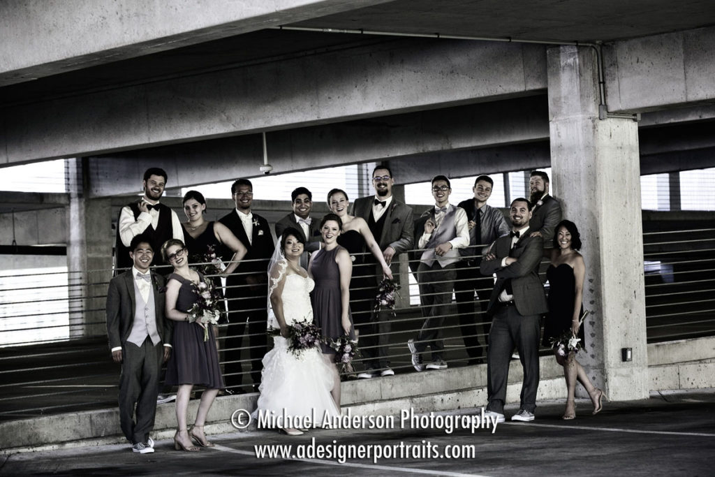 Colorized black & white wedding photo of a wedding party having some fun together. Wedding image taken in the parking ramp at Normandale Community College in Bloomington, MN.