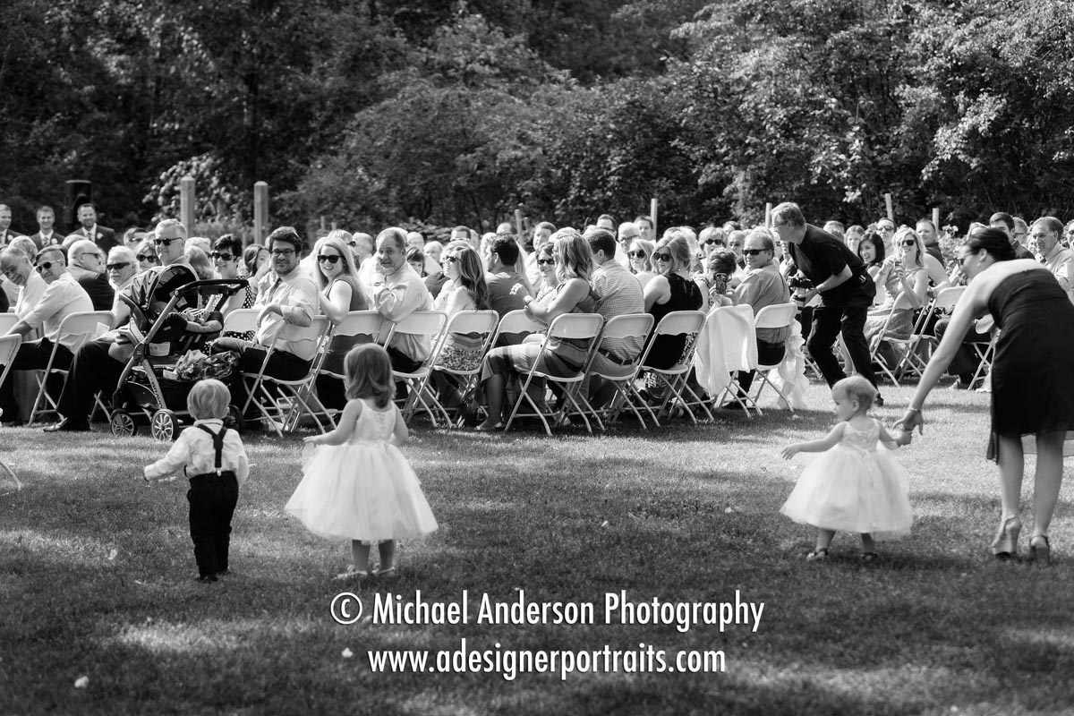 Funny wedding photo taken at a Grand View Lodge wedding in Nisswa, MN. Candid photo of two cute flower girls and an adorable ring bearer go off in different directions on their way to the aisle.