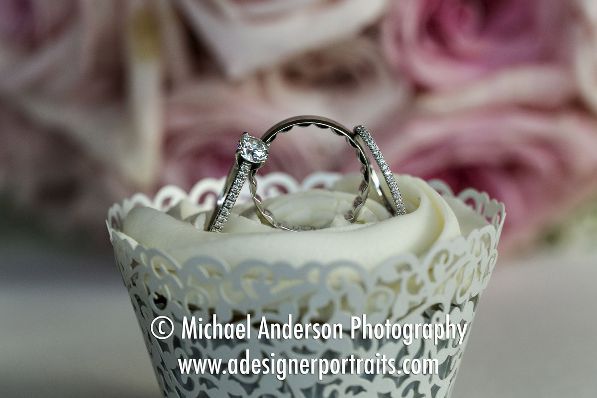 Close up photo of wedding rings in a cute cupcake. Wedding photo taken at their Saint James Hotel wedding.