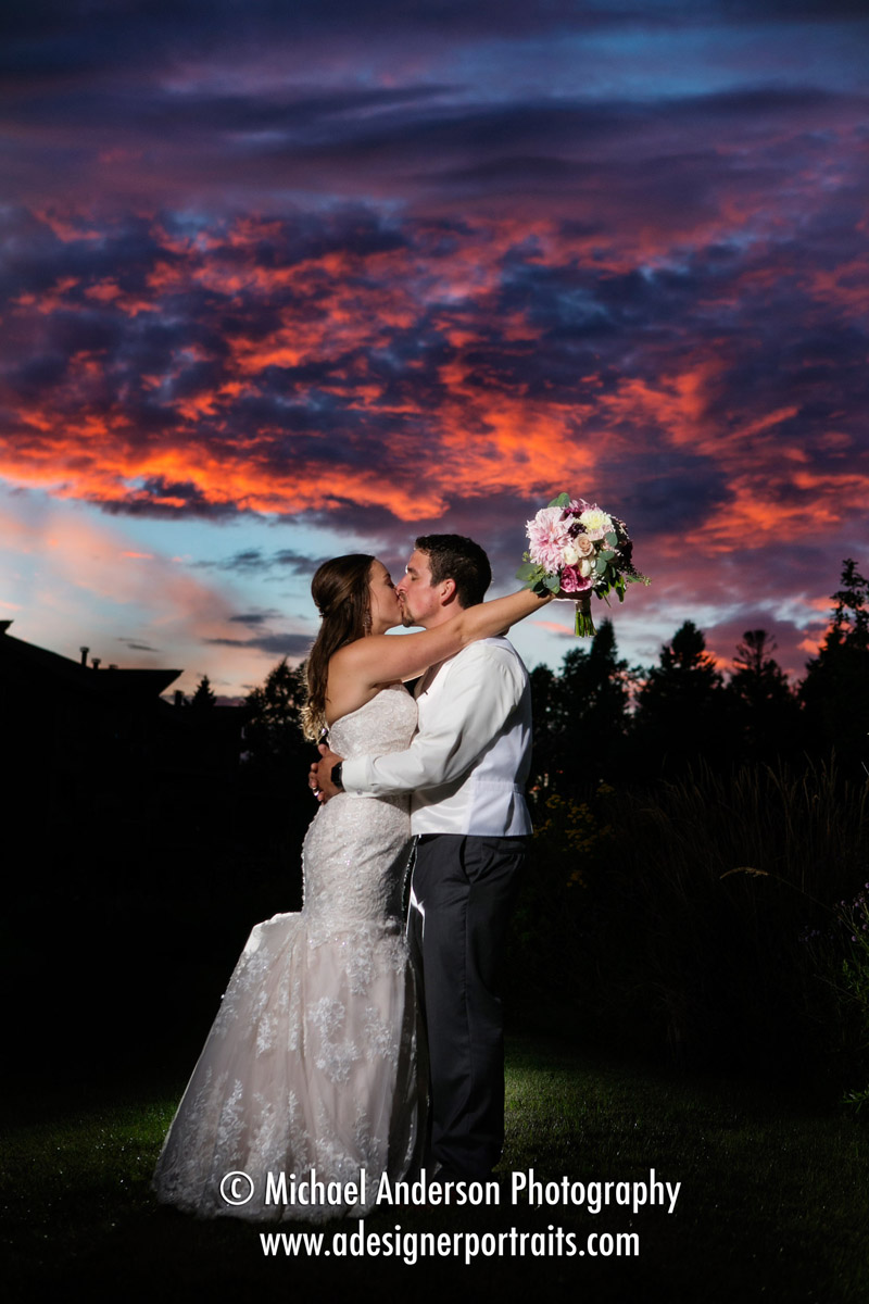 A pretty sunset wedding photo of Steve & Kaitlin kissing just after a rain storm at their Superior Shores wedding.