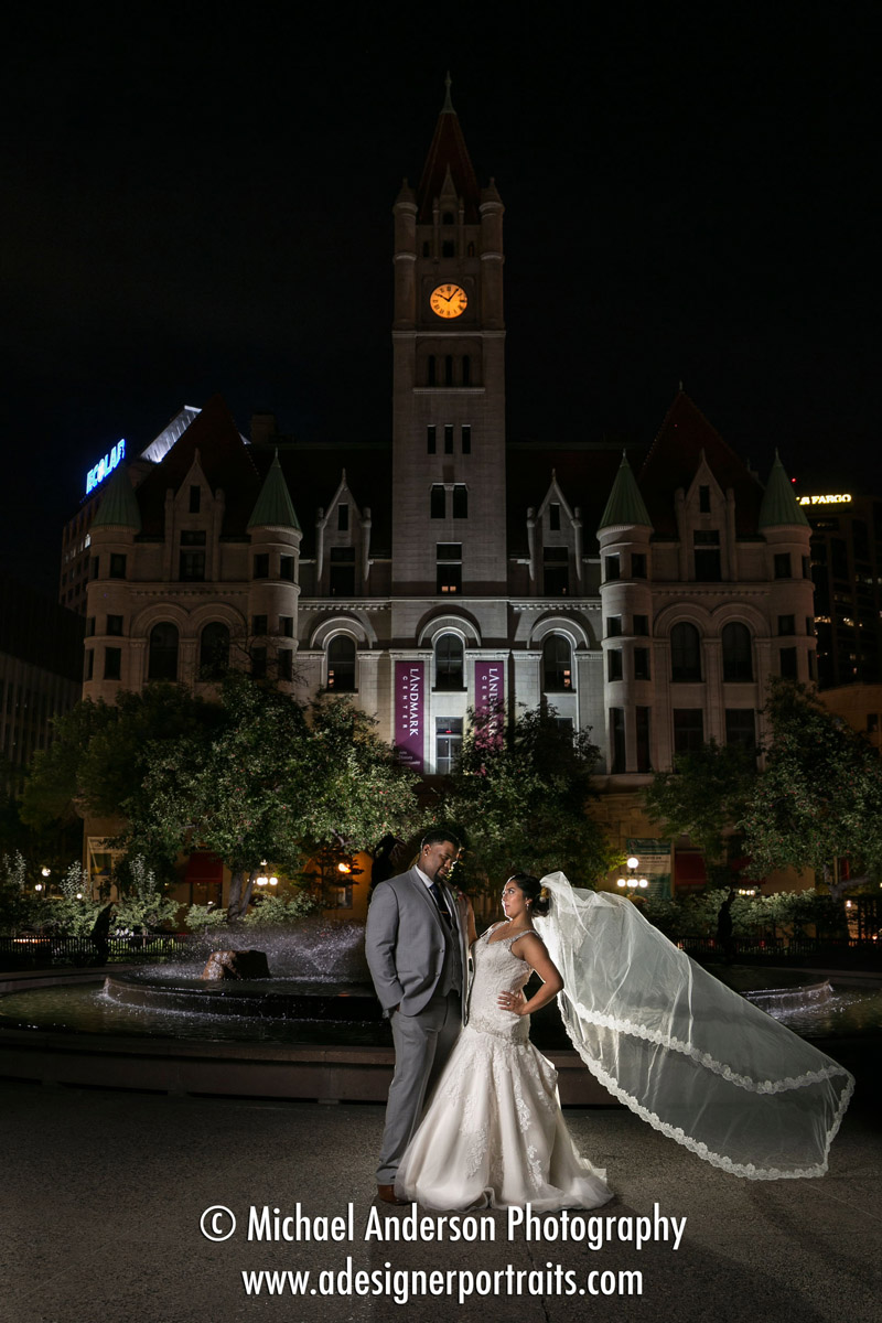 A fun nighttime wedding photo created by light painting with strobe lights. Photo of the bride and groom at Rice Park in downtown Saint Paul, MN.