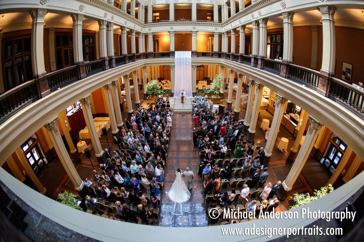 A very stunning wedding photograph of the bride and her father walking down the aisle during her Landmark Center wedding ceremony in downtown Saint Paul, MN. Unique wedding photo taken from the balcony with a Canon 5D Mark III and the Canon 15mm f2.8 EF fisheye lens.