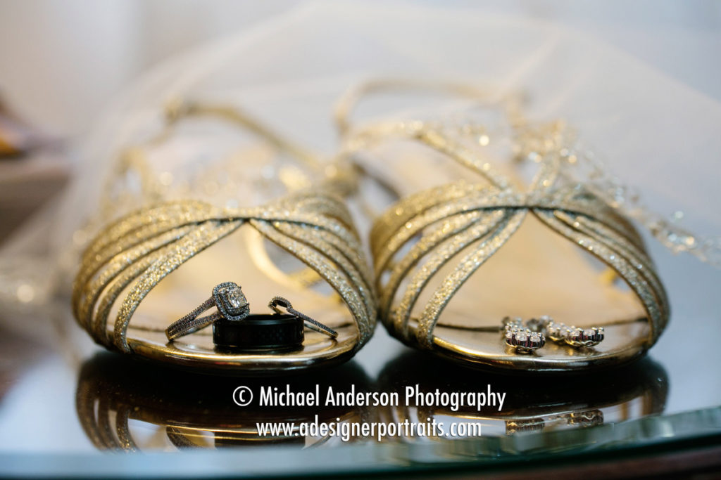 The bride and groom's wedding rings, Brooke's pretty shoes and earrings with her wedding veil in the background.