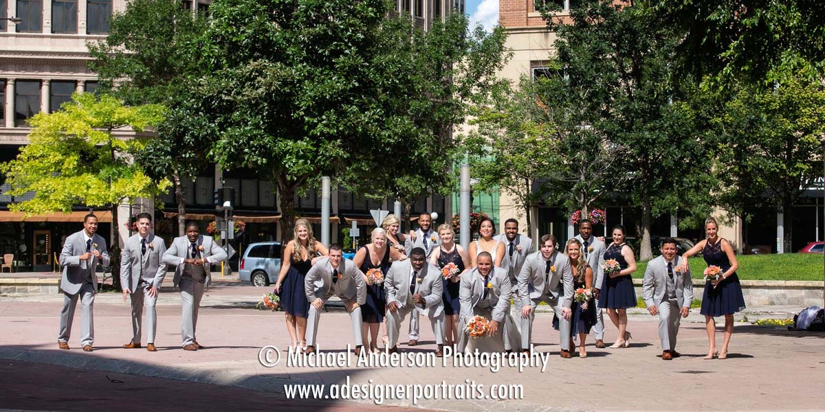 The bride & groom, a former college football player, and their wedding party in a football formation near Landmark Center in Saint Paul, MN.