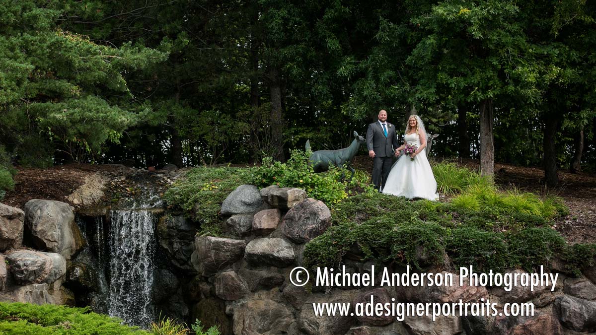 Wedding photography at The Wilds Golf Club Prior Lake MN. A pretty wedding photo of a bride & groom at The Wilds landmark waterfall.