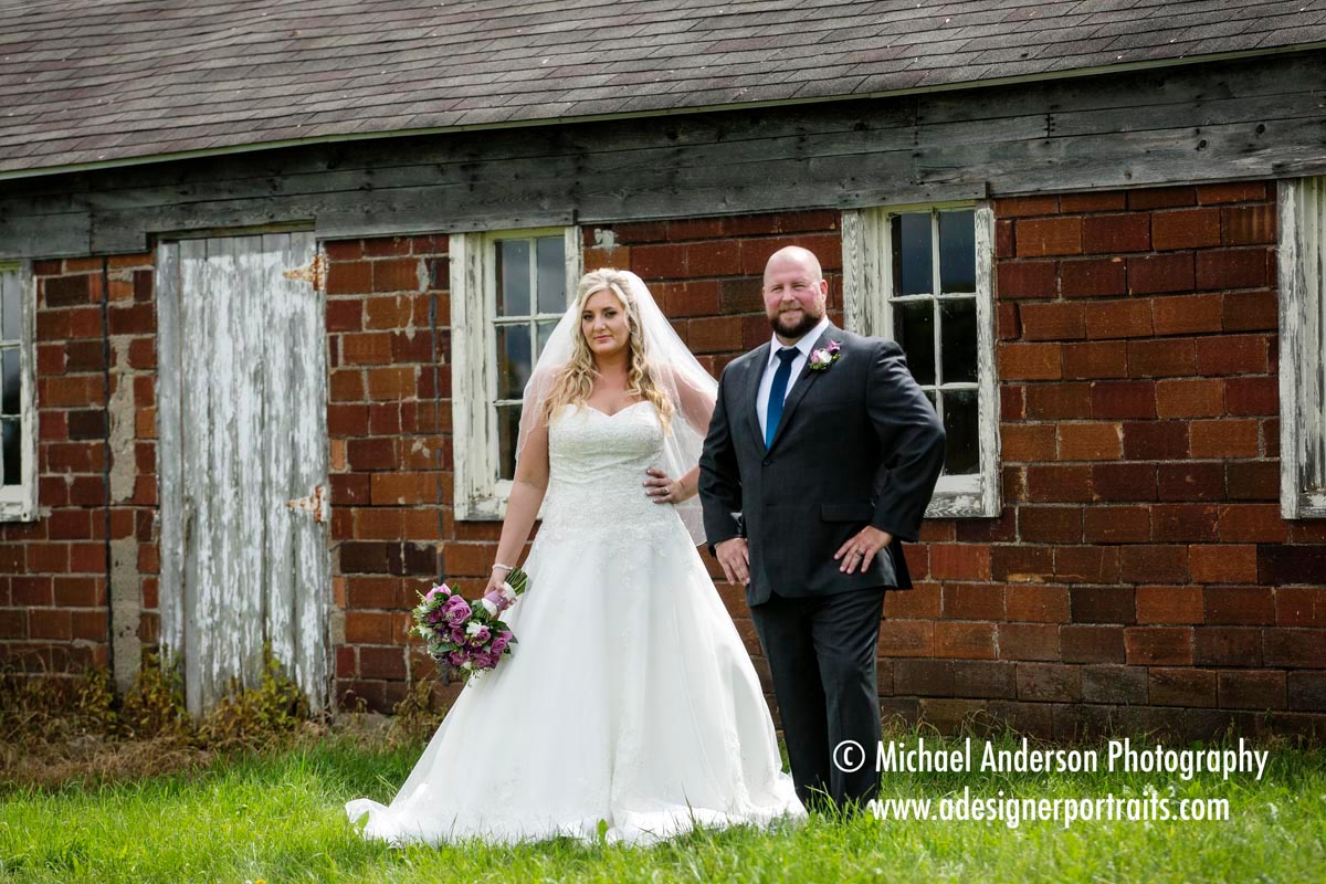 A fun bride & groom pose at an old abandoned barn in Prior Lake, MN.