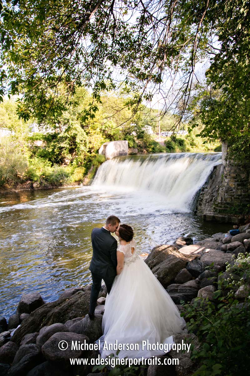 The bride & groom enjoy the pretty waterfall at Lagoon Park in Jordan, MN.