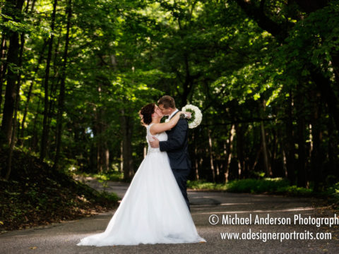 A very pretty wedding photograph of the bride & groom taken on the wooded driveway at Minnesota Harvest Apple Orchard in Jordan, MN.