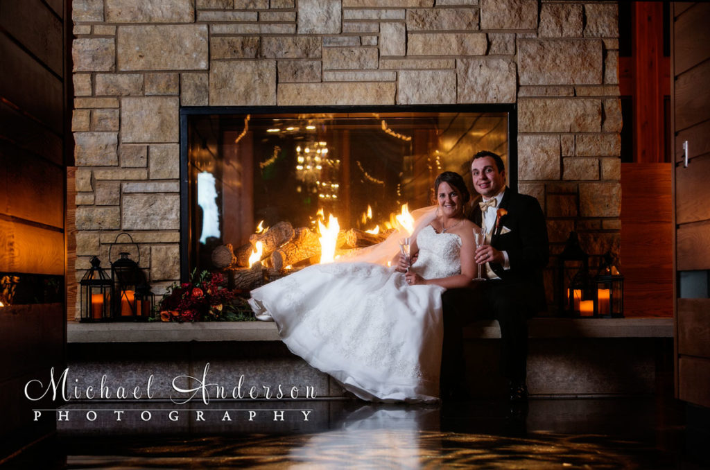 Aaron & Christina enjoy a glass of champaign in front of the beautiful fireplace at their Vadnais Heights Commons wedding reception.