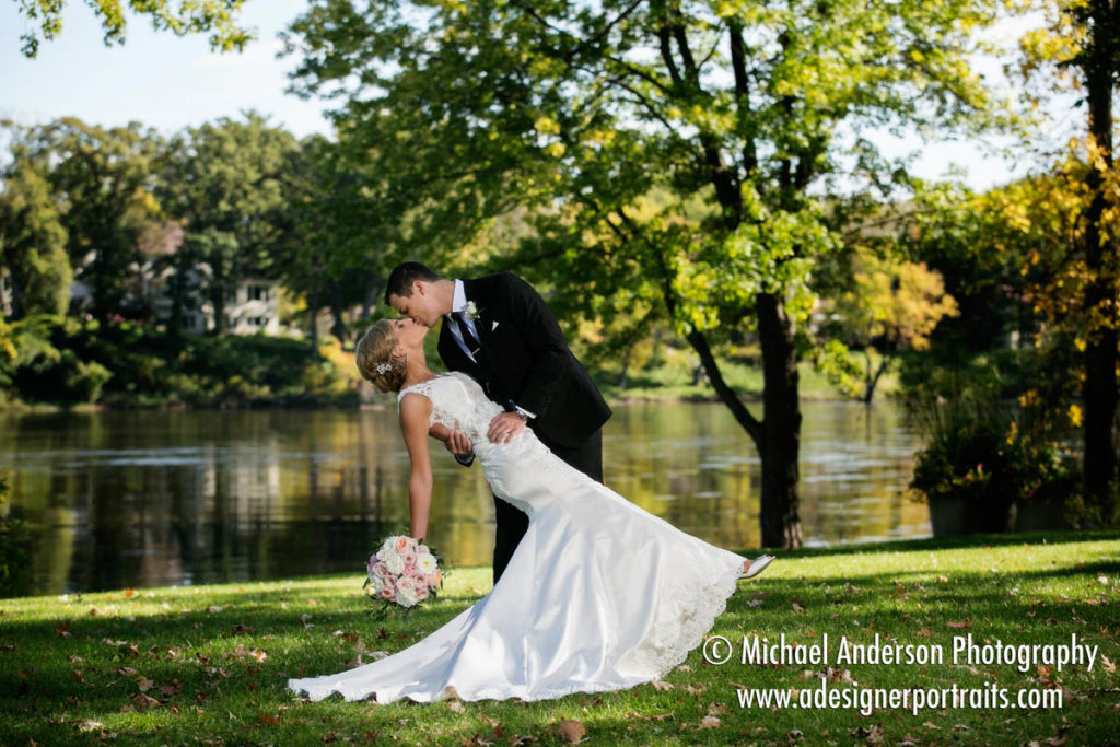 Pretty wedding photograph of the bride & groom kissing during a dip. Image taken on the banks of the Mississippi River at Mississippi Gardens in Minneapolis, MN.