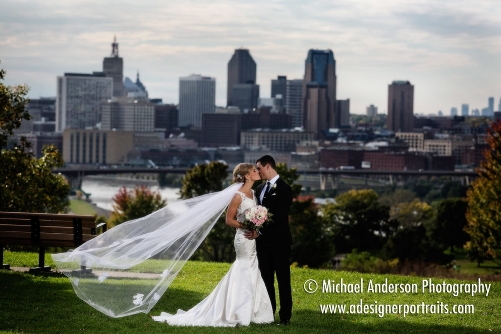 A pretty, scenic wedding photo of Charlie & Colleen with downtown St. Paul in the background. Image taken from Indian Mounds Regional Park in St. Paul, MN.