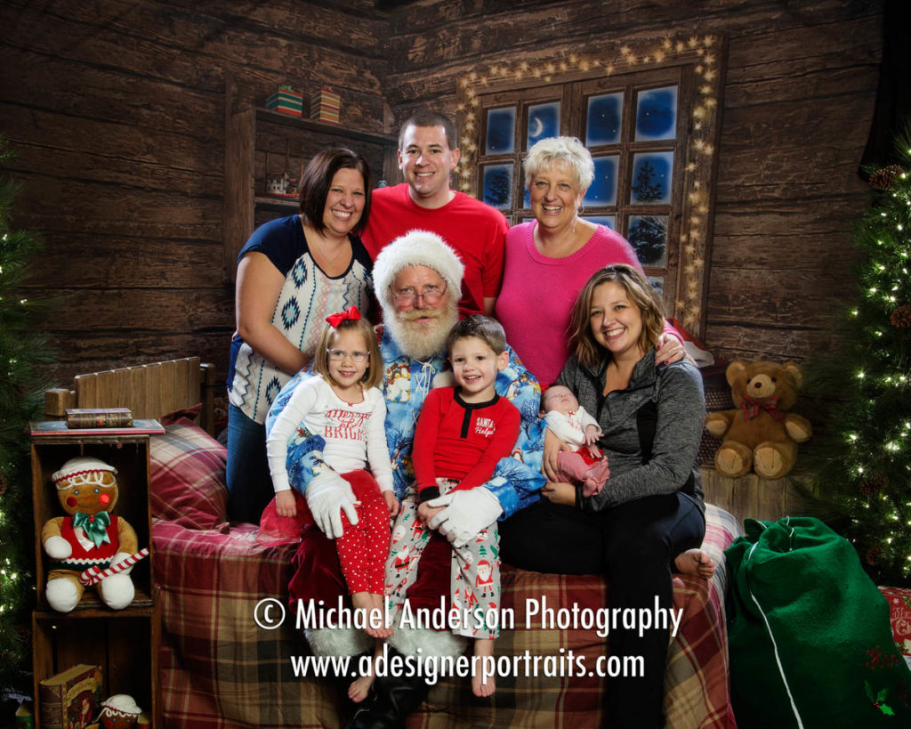 An entire family poses with Santa Claus during the kids 2016 Heirloom Santa Claus Portraits!