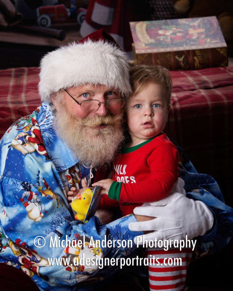 A super cute one year old boy gives Santa Claus a hug! Image created for his 2016 Heirloom Santa Photos benefiting Cystic Fibrosis.