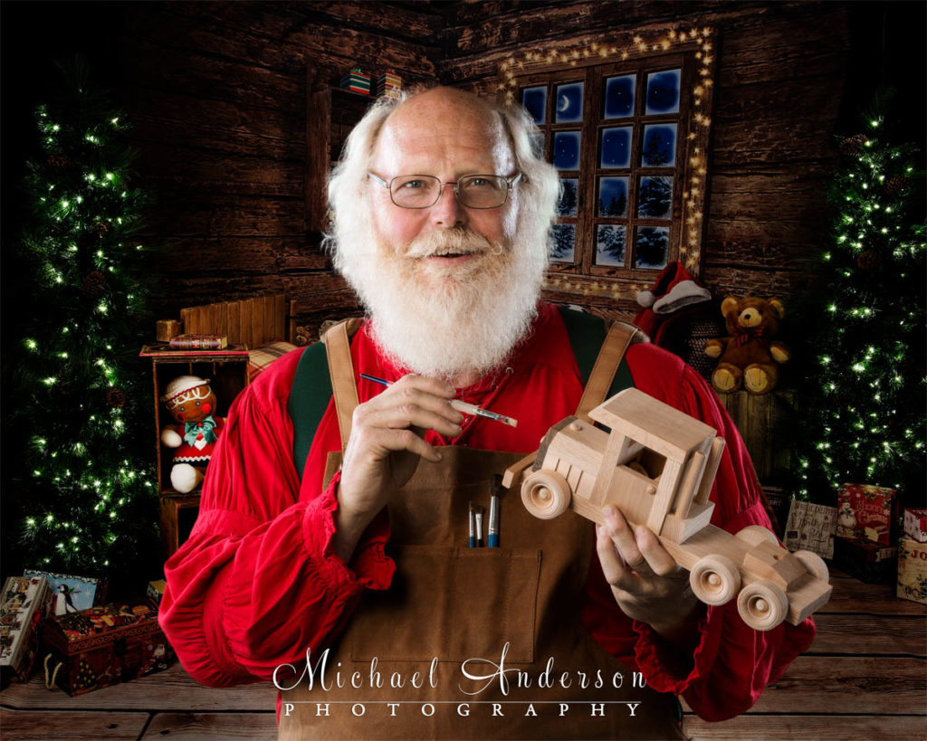 A photograph of Santa Claus painting a toy truck in his workshop on the North Pole.
