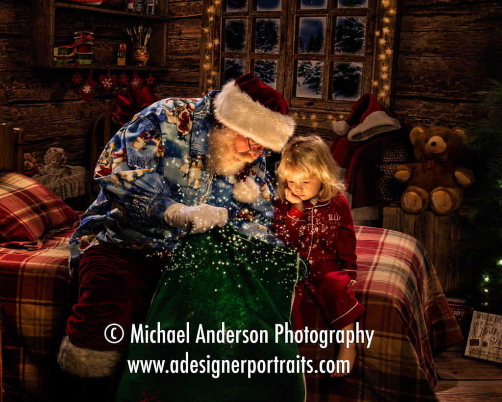 Beautiful Heirloom Santa Claus Portraits. Santa opens his toy bag to an adorable three year old girl wearing her Christmas pajamas. Portrait created during her heirloom Santa Portraits.