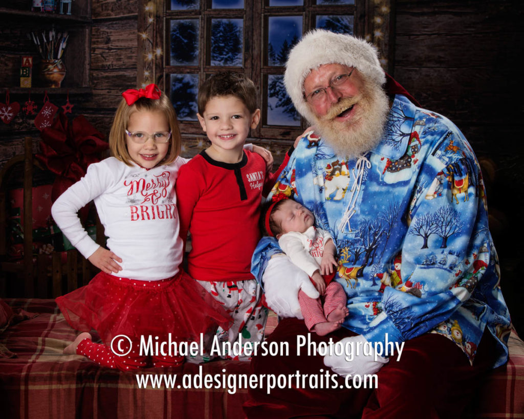 Three cute cousins, including a newborn baby girl, pose with Santa Claus during the kids 2016 Heirloom Santa Claus Portraits.