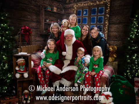 Grandma and both mom's pose with the four cute cousins and their Santa Claus portraits.