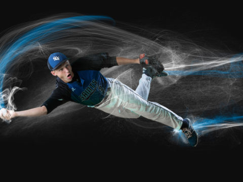 Saint Croix Falls High School baseball player taken on a green screen background. A baseball player is diving and making a throw. Image is after the green screen extraction has been done with school colors and special effects added.