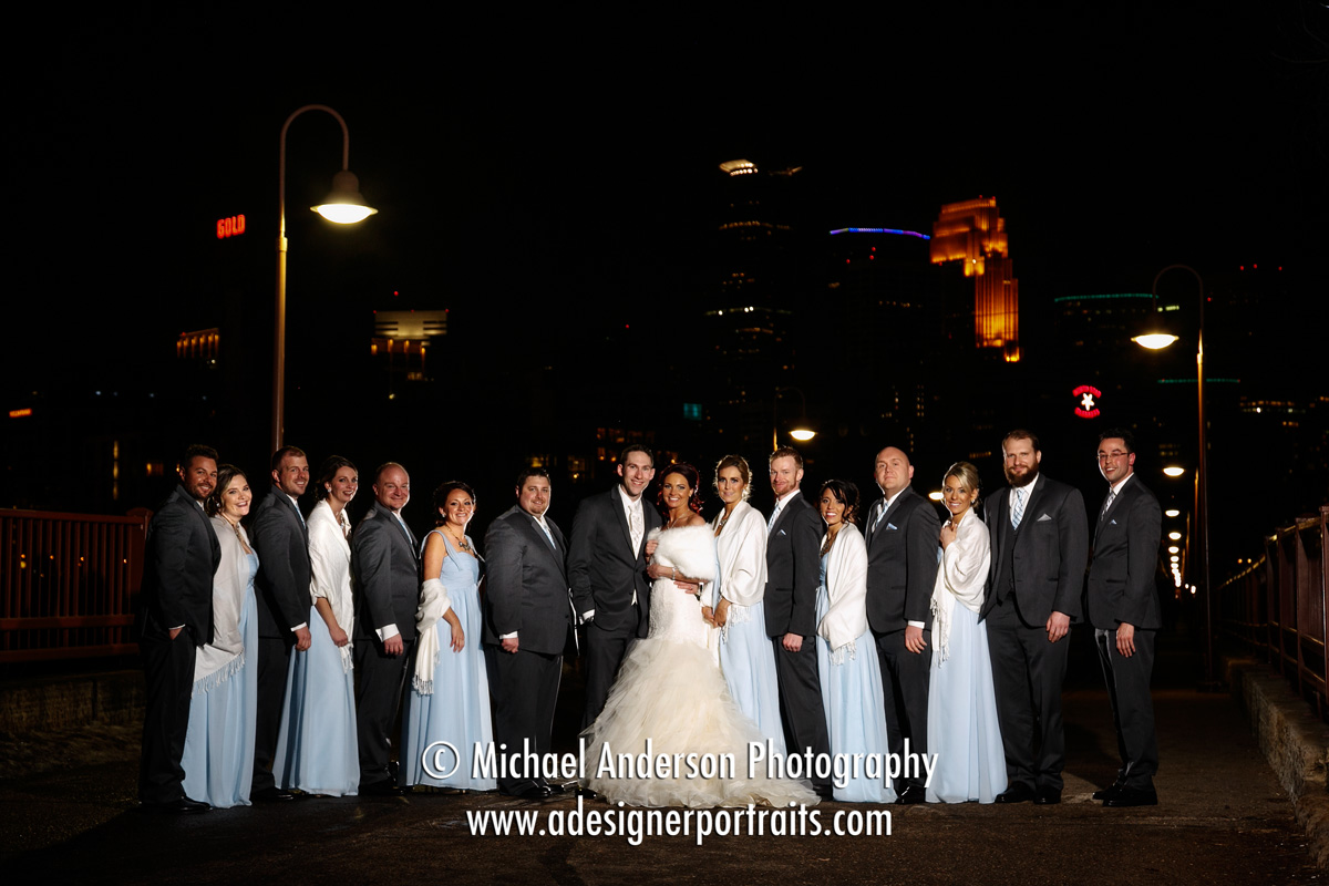 Nighttime wedding photo of Kate & Andrew's wedding party on the Stone Arch Bridge.
