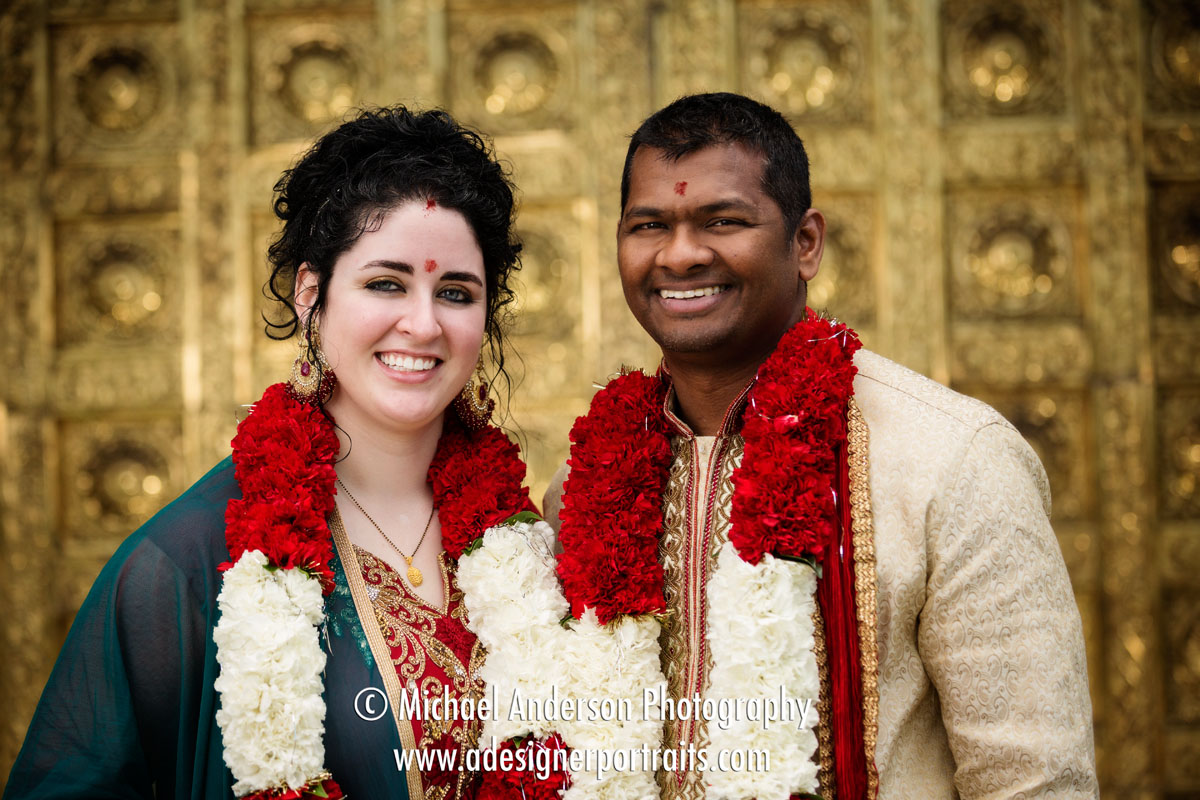 Bride and groom in front of the gold doors at their Hindu Temple of Minnesota wedding.