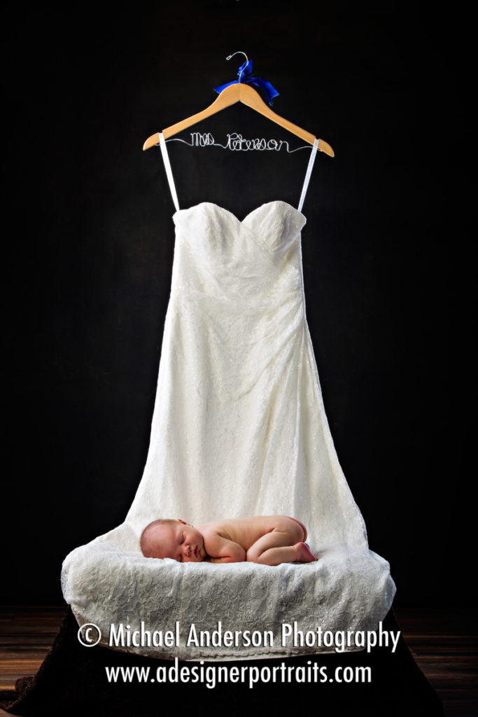 Two week old newborn portraits taken while the baby took a nap on her mom's wedding dress!