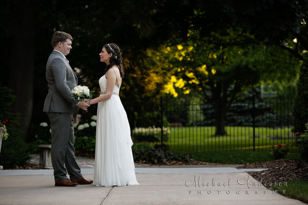 A Saint Paul College Club wedding photo of the bride and groom in front of the historic mansion just before sunset.