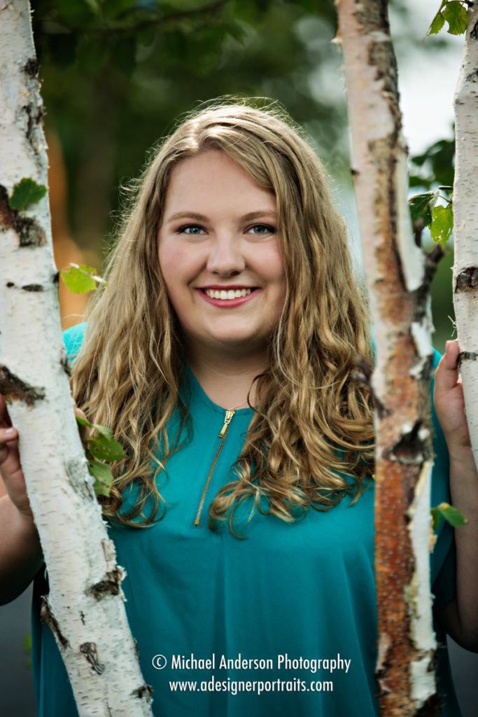 A pretty senior girl in the birch trees at Black Beach during her Lake Superior senior portraits.