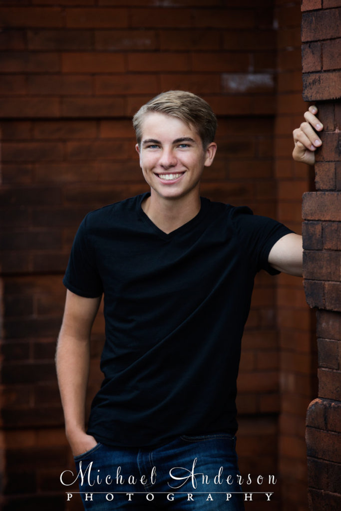 One of Ben's Lake Superior senior portraits taken by an old brick wall in Two Harbors, MN.
