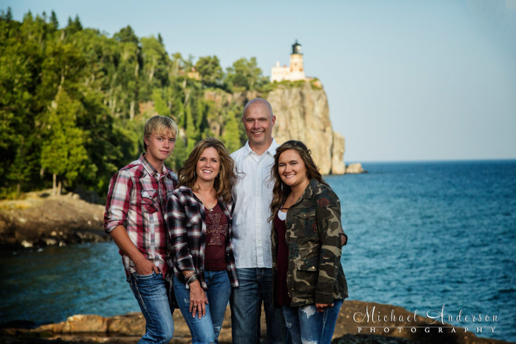 A family portrait created at Split Rock Lighthouse State Park with the iconic lighthouse in the distance.