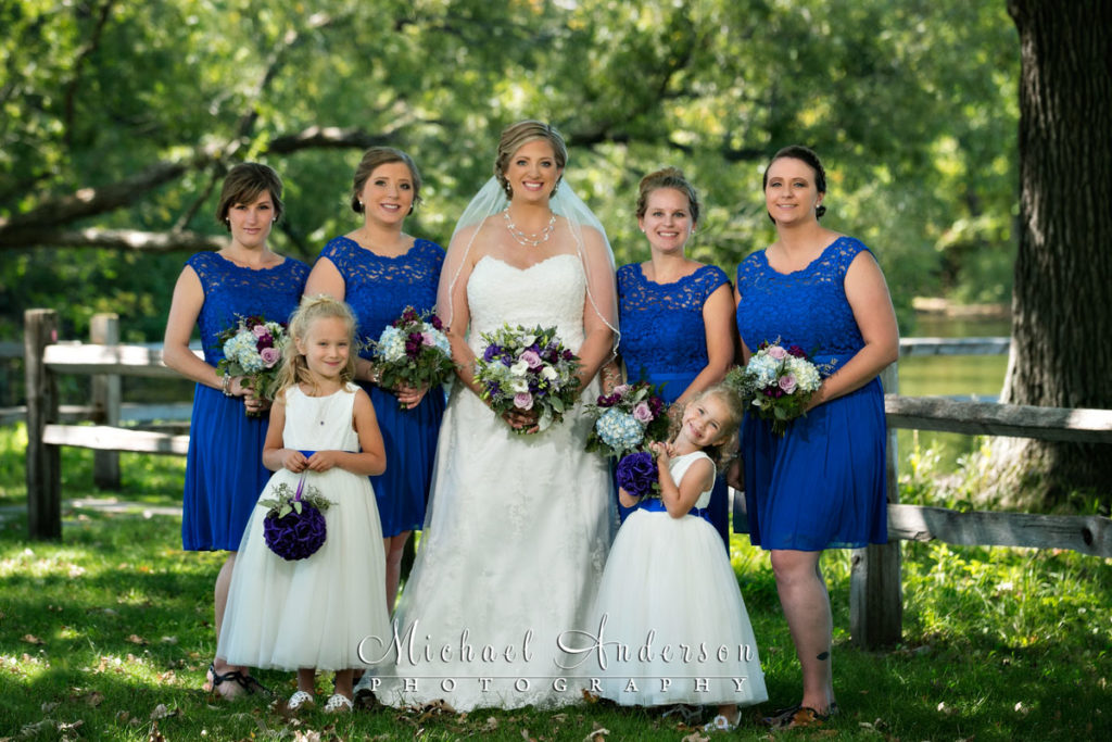 A very cute wedding photograph of the bride, her four bridesmaids and two cute flower girls. Image was created at Colby Lake Park in Woodbury, MN.