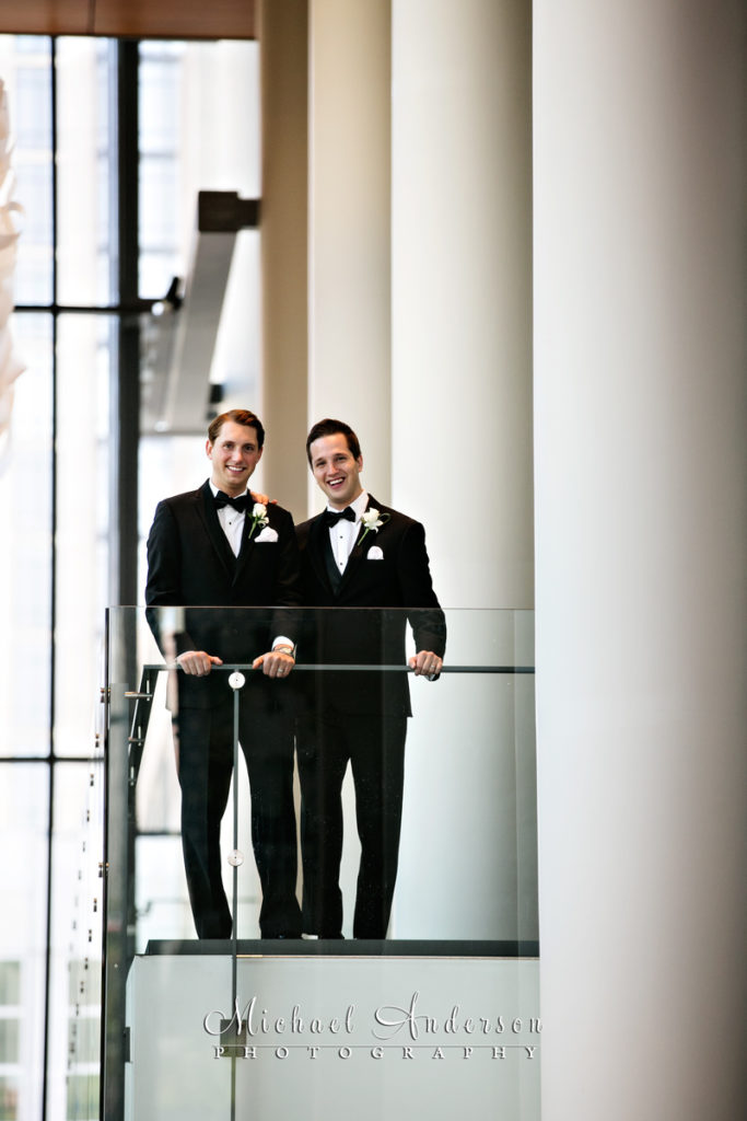 A classic Orchestra Hall wedding portrait of two grooms on the second floor balcony. Image was taken with a Canon 5D Mark III and a Tamron SP 150-600mm f/5-6.3 Di VC USD lens at 500mm.