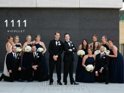 Orchestra Hall wedding photo of the two grooms and their wedding party just outside the front doors of the beautiful building in downtown Minneapolis, MN.