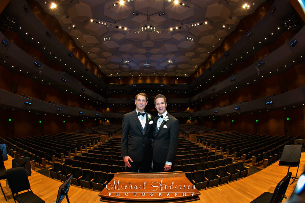 Two grooms on the stage at the conductors stand just moments before their Orchestra Hall wedding ceremony.